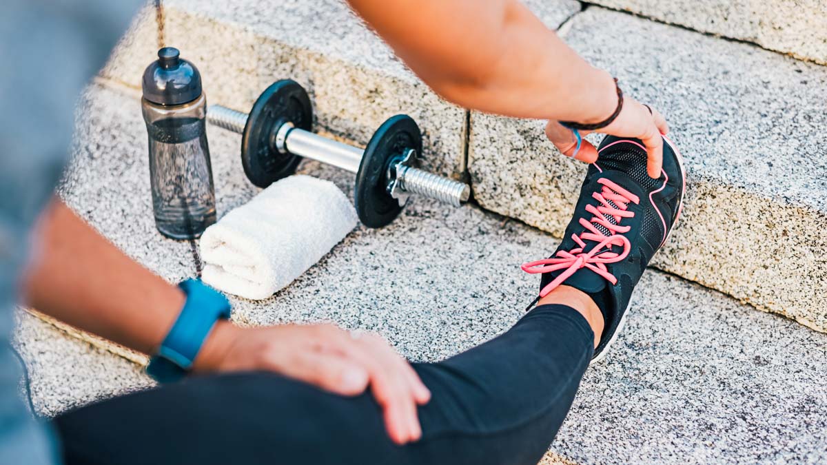 Sport Athlete Runner Female Stretching Leg On Urban Stone Stairs