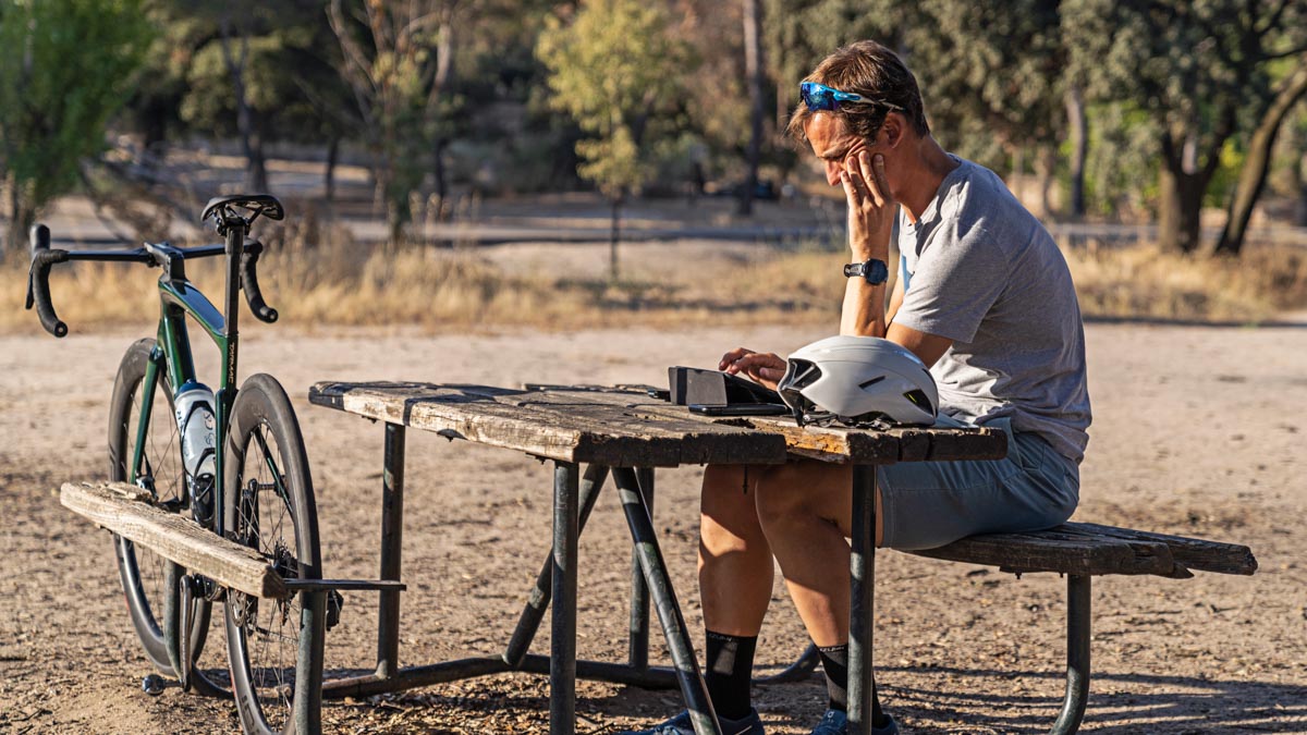 Cyclist Yago Alcalde Sitting On A Picnic Bench With Bicycle On Tablet