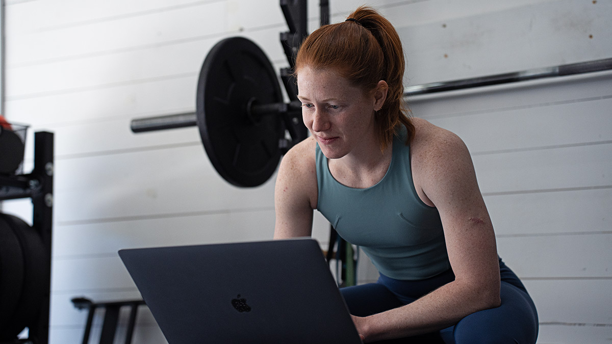 Strength Guide Chapter 4 Female Coach Programming Strength Training On Her Laptop